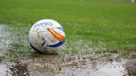 Un pallone da calcio dilettantistico su un campo impraticabile per pioggia