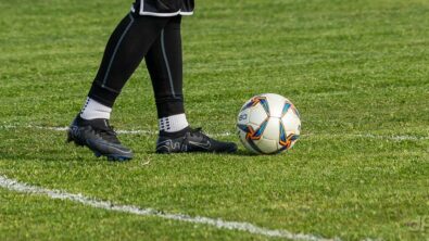 Portiere calcio dilettantistico con pallone ai piedi